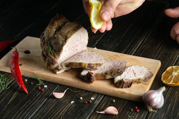 stock image The cook squeezes fresh lemon juice onto the grilled sliced beef. Place for advertisement or prescription on dark background