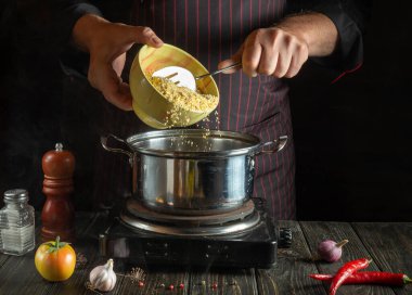 Deneyimli aşçı kahvaltıda mısır ezmeli yulaf lapası pişirir. Bir restoranın ya da otelin mutfağında sağlıklı diyet yemekleri. Sağlıklı yemek tarifi