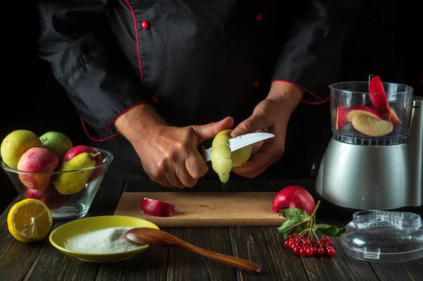 Chef peels an apple to prepare a sweet fruit drink in a blender or mixer. Healthy Vegetarian Breakfast or Dinner Idea.