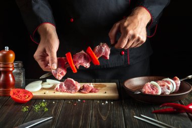 Profesyonel şef mutfakta çiğ kuzu etli şiş kebap hazırlıyor. Asya ulusal mutfağı.
