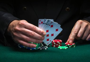 Bir oyuncu yeşil masadaki poker oyununda dört çeşit ya da dördüncünün galibiyet kombinasyonu üzerine bahse girer..