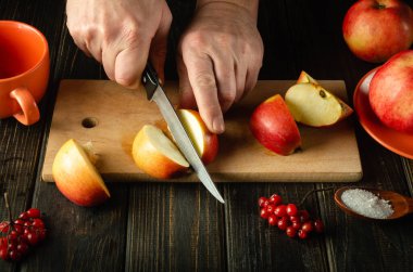 Aşçı komposto veya meyve suyu yapmak için elmaları kesme tahtasıyla keser. Bir dizi vitamin için elma diyeti. Boşluğu kopyala