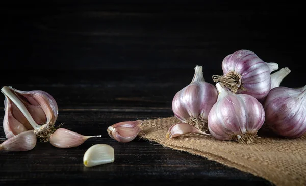 Garlic cloves on a black rustic table. Fresh peeled garlic and onions.