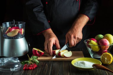 Professional chef prepares fruit jam from fresh apples. The cook cuts apples for chopping in a blender. Menu or recipe idea for hotel or restaurant