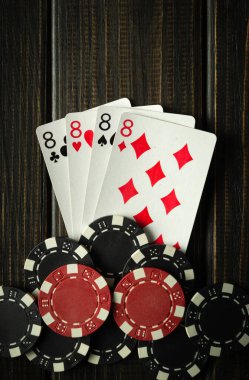 Playing cards with a winning combination of four of a kind or quads on a black vintage table in a poker club. Winning in sports depends on luck