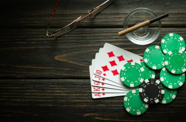 Poker kulübündeki siyah bir masada floş ve çiplerin kazanan kombinasyonuyla kağıt oynamak. Reklam için ücretsiz kopya alanı