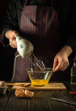 Şef lezzetli bir yumurta kahvaltısı ya da öğle yemeği hazırlamak için el yapımı elektrikli mikser kullanır. Restoran veya otel için menü fikri.