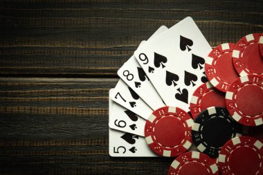 Floş kombinasyonuyla poker oynamak. Poker kulübündeki siyah şarap masasında çipli kartlar. Boşluğu kopyala.