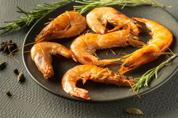 Stock image Shrimps with rosemary and spices in a bowl on a gray table. The idea of delicious dietary seafood for lunch or dinner.