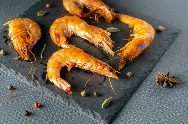 Shrimps on a serving board. The idea of a delicious delicacy or seafood for lunch in a restaurant.