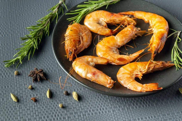 stock image Shrimps or prawns with rosemary in a bowl on a gray table. The idea of dietary seafood for lunch or dinner.