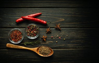 Siyah şarap masasındaki kırmızı biber ve kuru baharatlar yiyeceğe eklenmeye hazır. Menü veya tarif için boş alan