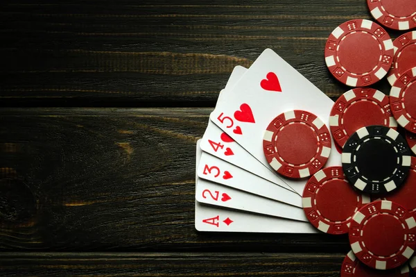 stock image Playing poker with a winning high card combination. Cards with chips on a black vintage table in a poker club. Copy space.