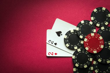 Bir çiftin kazanan kombinasyonuyla poker oynamak. Poker kulübündeki kırmızı masada fişleri olan kartlar. Boşluğu kopyala.