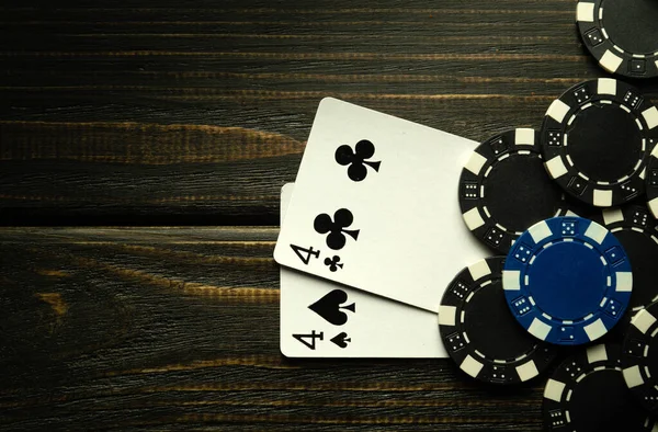 stock image Playing poker with a winning combination of one pair. Cards with chips on a black vintage table in a poker club.