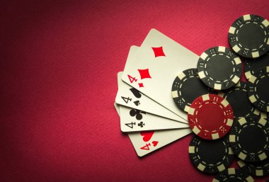 Poker oyununda dört çeşit ya da dört çeşit kazanan kombinasyon var. Poker kulübünde kırmızı masada fişleri olan kartlar.