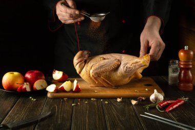 Şef kızarmadan önce çiğ ördeğe kırmızı biber ekler. Bir restoranın mutfağında yemek pişirmek veya bir aşçının elleriyle Pekin ördeği pişirmek..