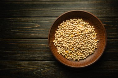 Koyu bir mutfak masasında pişmeden önce kuru bezelye ezmesi ile eski bir tabak. Bezelye lapalı ve sağlıklı yiyecekler..