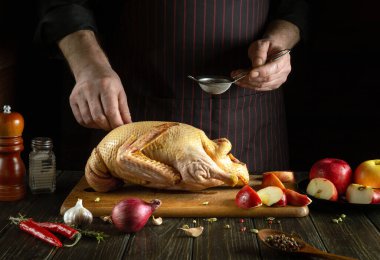 Tecrübeli şef kızarmadan önce çiğ ördeğe kırmızı biber ekler. Mutfakta bir aşçının elleriyle ulusal bir yemek pişirmek.