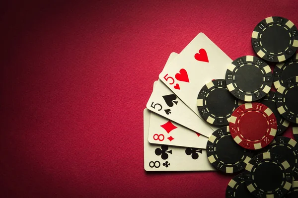 stock image Playing cards with a winning combination two pairs on a red table in a poker club. Winning in sports depends on luck.