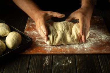 Fırıncı hamur yoğurur un ile çörek veya turta yapar. Fırında ya da evde şekerleme pişirme konsepti.
