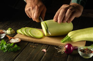 Aşçı lezzetli bir öğle yemeği ya da kahvaltı hazırlamadan önce sebze iliğini bıçakla küçük parçalara ayırır. Köylü yemeği ve sebzeleri..