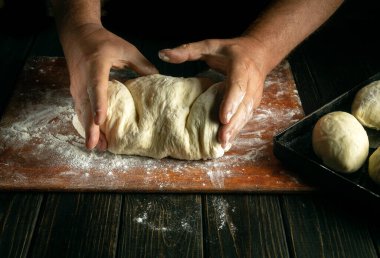 Fırıncı ellerinin hamur yoğurup un ya da çörek için hamur yoğurduğu yakın plan. Fırında pasta pişirme konsepti..