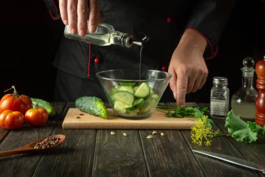 Kahvaltıda şefin elleriyle sebze salatası pişirmek. Salatalığa zeytinyağı ve domates salatası ekliyorum..