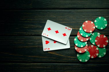 Bir çift kombinasyonlu poker oyunu. Poker kulübündeki siyah şarap masasında fişler ve kartlar. Reklam için boş karanlık alan