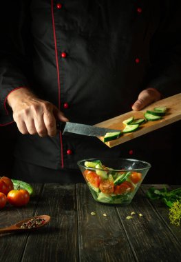 Şef mutfakta sebze salatası hazırlıyor. Vitamin Salatasına Taze Salatalık Ekleniyor