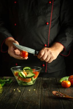 Profesyonel şef mutfakta sebze salatası hazırlıyor. Vitamin salatası için domates dilimi.