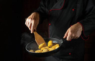 Çıtır nugget pişiriyorum. Aşçı dumanlı bir tavada dırdırı çevirir. Reklam alanı olan bir otel için büyük bir mutfak fikri.