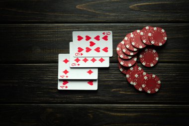 Poker kulübünde siyah bir masada iki çift kazanan kombinasyonla kağıt oynamak. Sporda kazanmak şansa bağlıdır.