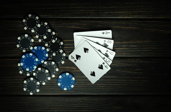 A poker game with a lucky winning combination of high cards. Cards with chips received for winning on a black vintage table in a poker club.