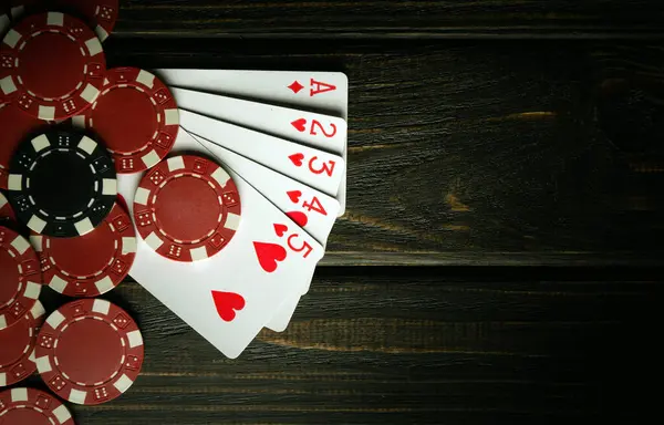A very popular poker game with a winning combination of high cards. Cards with chips on a black vintage table in a poker club.