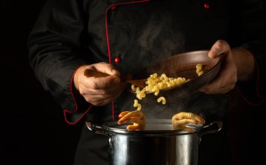 Şefin elleriyle kaynamış tavuk bacağına makarna ekliyorum. Restoranın ya da otelin mutfağında lezzetli bir çorba hazırlama kavramı..