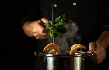 Aşçı kaynar tavuk budu tenceresine yeşil maydanoz ekler. Restoranın mutfağında ya da otelinde lezzetli çorba ya da et suyu hazırlama kavramı.