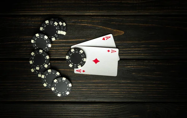 A very popular poker game with one pair combination. Chips and cards on a dark vintage table in a poker club. Free advertising space.