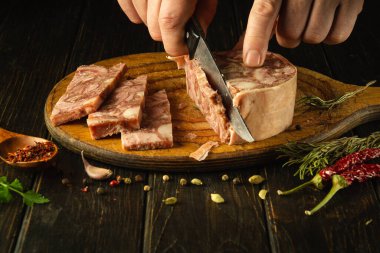 Tatil masasını kurmadan önce mutfak tahtasının üzerinde peynir dilimlemek. Kas keserken bir adamın elinde bıçak..