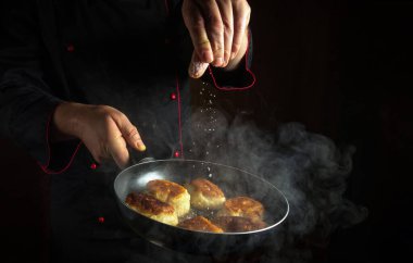 Profesyonel bir şef tavada sıcak krep tuzlar. Orası menü veya yemek tarifi için bir yer..