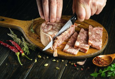 Et yemeği pişiriyorum. Aşçı mutfak kesme tahtasındaki bir bıçakla et kaslarını kesiyor. Çalışırken aşçı ellerinin yakın çekimi.