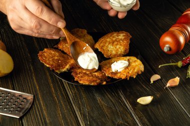 Patatesli krep ve ekşi krema pişiriyorum. Servis yapılırken kaşığı aşçının elinde tutuyordu..