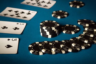 Poker kulübünde kağıt oynayıp, mavi bir masada fiş kazanmak. İki çiftten kart kombinasyonu kazanma kavramı.