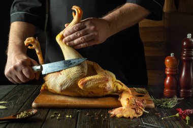 Şef yemek odasında çiğ bir horozu bıçakla keser. Öğle yemeği için baharatlı tavuk pişiriyorum. Asya mutfağı.