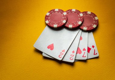 Poker fişleri ve kartları sarı bir masada iki çift kombinasyonlu bir kulüpte. Kazanmak şansa bağlıdır..