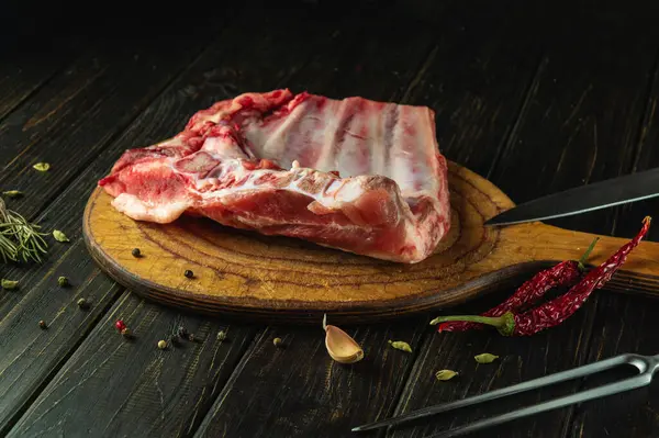 Kebap yapıp doğramadan önce bıçakla pirzola dilimlemek. Mutfak masasında baharat ve etle birlikte çalışma ortamı. Asya mutfağı.