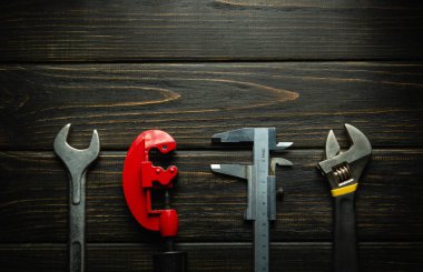 Siyah bir şarap masasında tamir ve inşaat için profesyonel aletler. Tesisat ürünleri ve ekipman onarım konsepti. Reklam alanı.