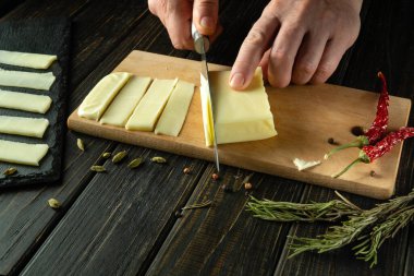 Aşçı, sofra kurmak için Mozzarella peynirini ince şeritlere ayırmak için bıçak kullanıyor. Öğle yemeğinde mandıra servisi yapmak gibi basit bir kavram..