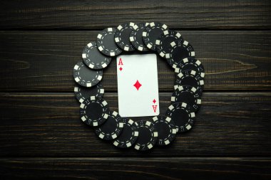 Kulüp binasında eski bir masada kazanmaktan siyah çipli kart ası oynamak. Poker oyununda şans sembolü düşük tuş kavramı.