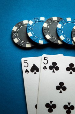 Kulüpteki mavi poker masasında bir çiftin kazanan kombinasyonu. Kart ve çiplerle başarılı poker konsepti.